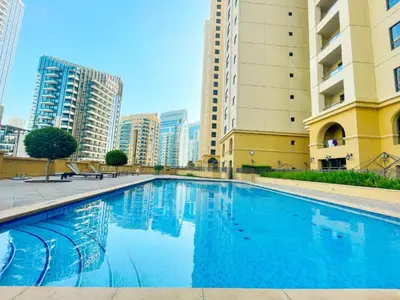 a large swimming pool in a city with tall buildings at Duplex 2BR next to Marina Beach in Dubai
