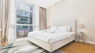 a white bedroom with a large bed and a window at City Walk Building 16, Al Wasl, Jumeirah - Mint Stay in Dubai