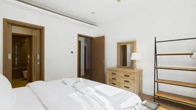 a white bedroom with a bed and a dresser at City Walk Building 16, Al Wasl, Jumeirah - Mint Stay in Dubai