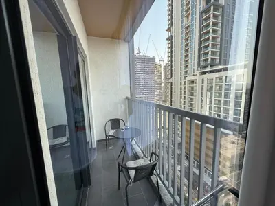 a balcony with a table and chairs on a building at Elegant 1-Bedroom The Crest, Near Downtown Dubai in Dubai