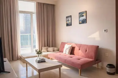 a living room with a pink couch and a table at Family Stay in Downtown 2BR Sleeps 6 Burj View in Dubai