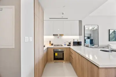 a kitchen with a white counter top and wooden cabinets at Luxury 1BR Apt at LIV Marina with Direct Marina Views in Dubai