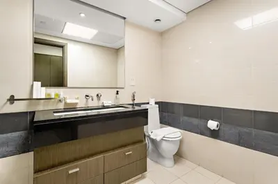 a bathroom with a toilet and a sink and a mirror at FIRST CLASS 1BR Central Dubai Luxury Living in Dubai