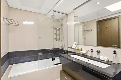 a bathroom with a sink and a large mirror at FIRST CLASS 1BR Central Dubai Luxury Living in Dubai
