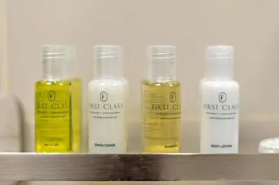 a row of bottles of first class oils on a shelf at FIRST CLASS 1BR Central Dubai Luxury Living in Dubai