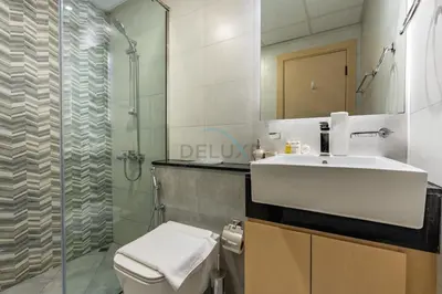 a bathroom with a toilet and a sink and a shower at Spacious Balcony with Breathtaking Creek Views, Just a Short Drive from Zabeel Stadium, Al Jaddaf Walk, and Cactus Park, Binghatti Avenue, Al Jaddaf by Deluxe Holiday Homes in Dubai