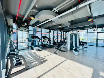a gym with cardio equipment in a building with windows at Spacious Balcony with Breathtaking Creek Views, Just a Short Drive from Zabeel Stadium, Al Jaddaf Walk, and Cactus Park, Binghatti Avenue, Al Jaddaf by Deluxe Holiday Homes in Dubai