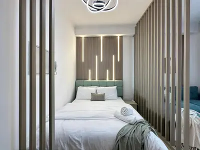 a bedroom with a bed with a green headboard at Minimalist Studio with Amazings Marina Canal Views in Dubai