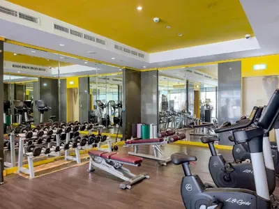 a gym with a lot of treadmills and machines at Modern 2BR Apartment in Merano Tower, Business Bay in Dubai