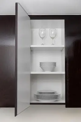 a cabinet with two wine glasses and plates in it at Modern 2BR Apartment in Merano Tower, Business Bay in Dubai