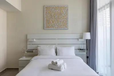 a bedroom with a white bed with towels on it at Modern 2BR Apartment in Merano Tower, Business Bay in Dubai