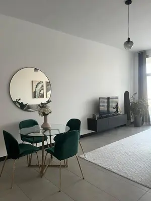 a dining room with a table and chairs and a mirror at Specious 1 bd close to Sea Jumeirah in Dubai