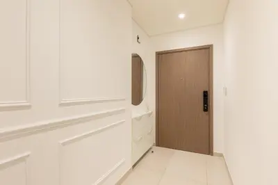 a hallway with a wooden door and white walls at Spacious 2BR with Burj Khalifa View in Downtown Dubai in Dubai