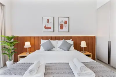 a bedroom with a large white bed with two lamps at 2Bed with spectacular Burj Khalifa & fountain view in Dubai