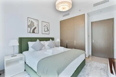a bedroom with a large bed with a green headboard at 2Bed with spectacular Burj Khalifa & fountain view in Dubai