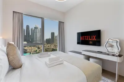 a white bedroom with a view of a city at 2Bed with spectacular Burj Khalifa & fountain view in Dubai