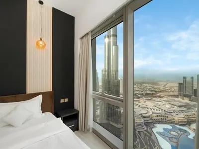 a bedroom with a large window with a view of a city at 2BR balcony Downtown with Burj Khalifa and Fountain View in Dubai