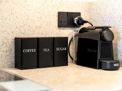 a coffee tea mixer and three books on a shelf at Stylish 2 bedroom - Marina Views - Private Beach in Dubai