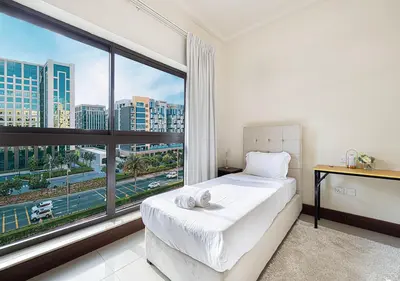 a bedroom with a bed and a large window at Cozy 2 Br Heart of Palm Jumeirah in Dubai
