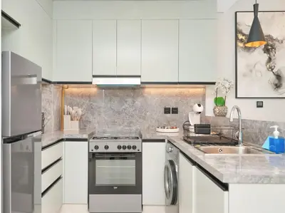 a white kitchen with a stove and a sink at Golf View Modern Comfort Perfect for 3 Guests in Dubai