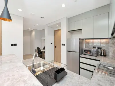 a kitchen with a sink and a refrigerator at Golf View Modern Comfort Perfect for 3 Guests in Dubai