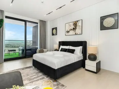 a bedroom with a large bed and a large window at Modern Studio with Jacuzzi and Premium Amenities in Dubai