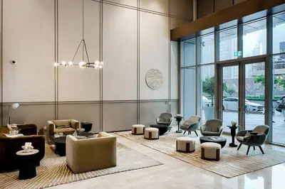a lobby with chairs and tables in a building at Luxury Apartments at Grande with Burj Khalifa & Fountain View Walk to Dubai Mall, Private Cinema in Dubai