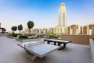 a picnic table on a rooftop with a view of a city at Homey 1BR apartment in Creek Harbour in Dubai