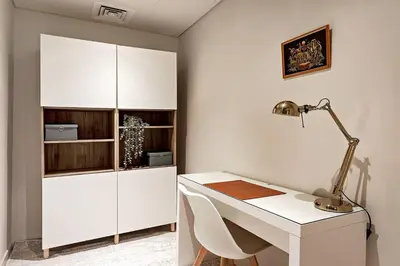 a white office with a desk and a lamp at Commodious 3BR Apartment Canal View Creek Harbor in Dubai