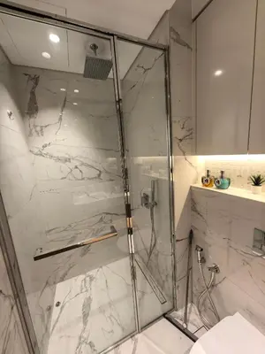 a shower with a glass door in a bathroom at 10 min to Burj Khalifa 1BR in Hotel-style building Luxury Stay in Dubai