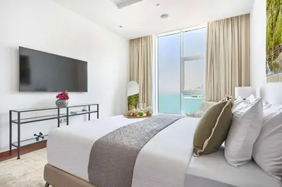 a bedroom with a large bed with a large window at Frank Porter - Tiara Residence Diamond North 4 in Dubai