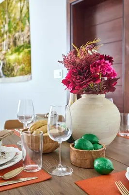 a table with wine glasses and a vase with flowers at Frank Porter - Tiara Residence Diamond North 4 in Dubai