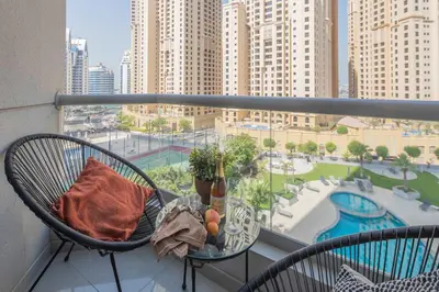 a balcony with a table and chairs and a view of a city at Frank Porter - Marina Wharf 1 in Dubai