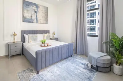 a bedroom with a bed and a chair and a window at Frank Porter - Marina Wharf 1 in Dubai