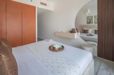 a bedroom with a bed with a bowl of flowers on it at Frank Porter - Lakepoint N2 in Dubai