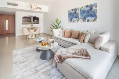 a white living room with a couch and a table at Frank Porter - Lakepoint N2 in Dubai