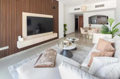 a living room with a white couch and a tv at Frank Porter - Lakepoint N2 in Dubai