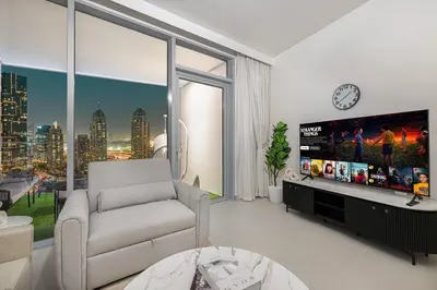 a living room with a chair and a large window at Marina Horizon by LIV High Floor 1BR, For 5 Guests, Dual Gyms & Marina View in Dubai