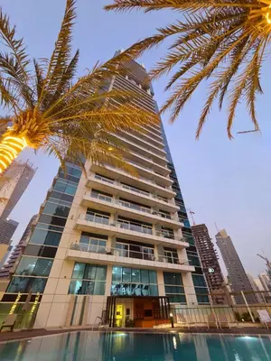 a tall building with a palm tree in front of it at Apartment in Dubai Marina with Sea View & Balcony & Pool in Dubai