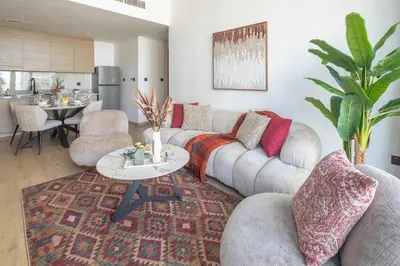 a living room with a couch and a table at Frank Porter - Acacia, Park Heights Tower A in Dubai