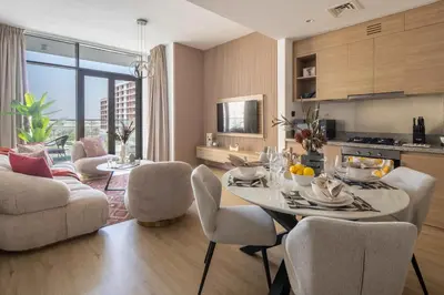 a kitchen and living room with a table and chairs at Frank Porter - Acacia, Park Heights Tower A in Dubai