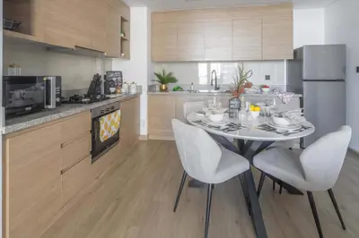 a kitchen with a table and chairs in a kitchen at Frank Porter - Acacia, Park Heights Tower A in Dubai
