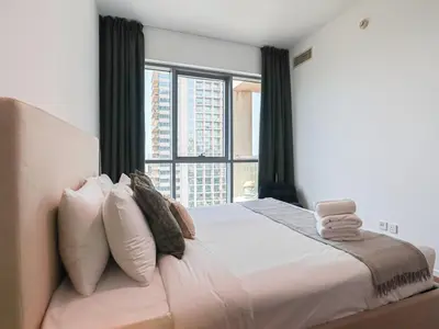 a bedroom with a large bed with a large window at HiGuests - 2 BR Escape Golf View Haven in The Greens in Dubai