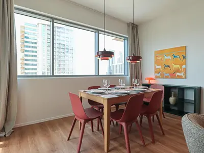 a dining room with a table and red chairs at HiGuests - 2 BR Escape Golf View Haven in The Greens in Dubai