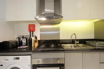 a kitchen with a sink and a stove at King Bed Suite - Canal Views - Pool, Gym & Balcony in Dubai