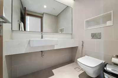a white bathroom with a sink and a toilet at Parkside 2BR plus Maid Canal Front in Dubai