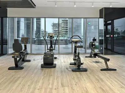 a gym with several treadmills and elliptical machines at Parkside 2BR plus Maid Canal Front in Dubai
