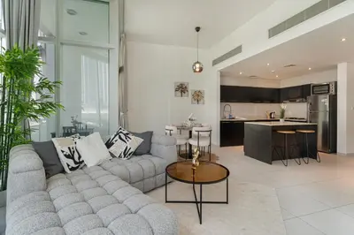 a living room with a couch and a kitchen at Modern 2 Bedroom in Dubai Marina - Sea View in Dubai