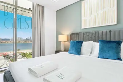 a bedroom with a large bed with blue pillows at Stunning Full Sea View 3BR Luxurious Palm Jumeirah in Dubai