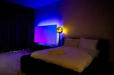 a bedroom with a bed and a tv with purple lights at Stylish Studio with Stunning City Views in Dubai